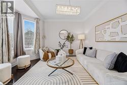 Living area featuring crown molding, wood finished floors, and hanging lights - 