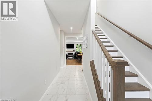 Staircase with wood-finish treads and handrails, white risers, and white balusters - 39 Dunning Way, St. Thomas, ON 
