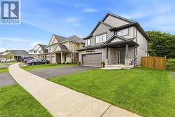 Contemporary two-story home featuring a stone and siding exterior, an attached two-car garage, a covered front porch, and a wooden privacy fence - 