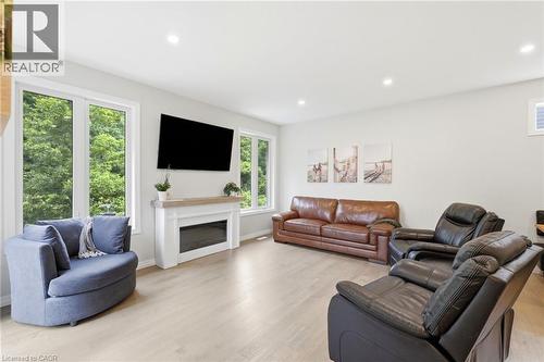 Living area featuring light wood-finish flooring, recessed lighting, and a white fireplace mantel with a light wood top - 39 Dunning Way, St. Thomas, ON 