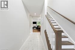 Staircase with wood-finish treads and handrails, white risers, and white balusters - 