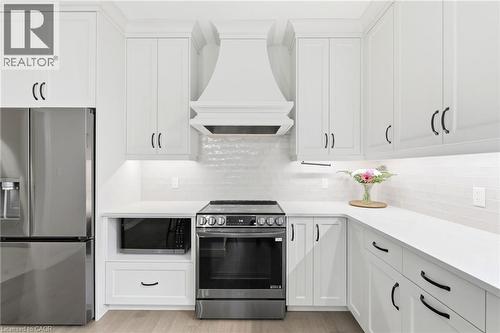 Contemporary kitchen featuring white shaker cabinetry, stainless steel appliances, and sleek countertops - 39 Dunning Way, St. Thomas, ON 
