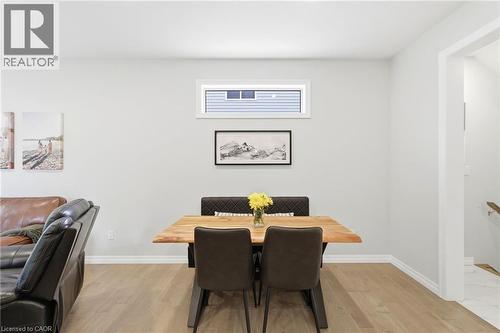 Open-concept living area featuring light wood-finish flooring, a contemporary wall color, and a high horizontal window - 39 Dunning Way, St. Thomas, ON 