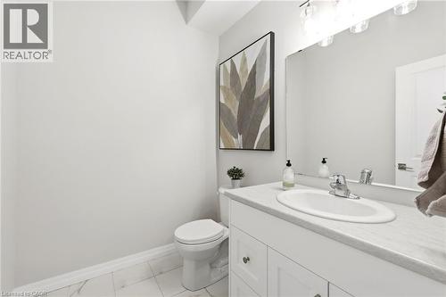 White vanity with an integrated oval sink, light-toned countertop, and clear glass vanity lighting - 39 Dunning Way, St. Thomas, ON 