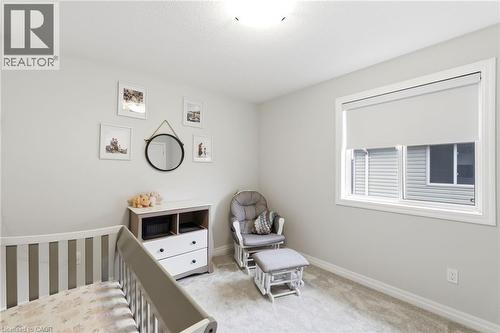 Neutral tone room featuring plush carpet flooring, a single window with a white roller shade, light gray painted walls, and white trim - 39 Dunning Way, St. Thomas, ON 