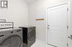 Dedicated laundry space featuring white walls and a white two-panel door - 
