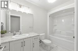 Bathroom featuring a white vanity with an oval basin sink, patterned countertop, and a wide mirror - 