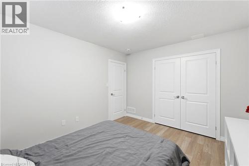 Bedroom featuring light wood-finish flooring, light grey painted walls, and white trim - 39 Dunning Way, St. Thomas, ON 