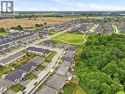 Aerial perspective showcasing a residential community with varied home styles, expansive green spaces, and mature tree lines - 