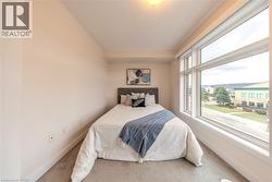Room featuring a large window with white framing, light-colored walls, and carpeting - 