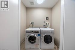 Dedicated laundry alcove featuring wall connections for appliances and light-toned wall paint - 