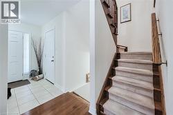 Tiled foyer with wood-finish flooring extending into the hall - 