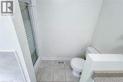 Shower enclosure with frosted glass paneling and a clean white toilet - 
