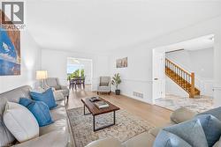 Bright living area featuring wood-finish flooring and white walls with wainscoting - 