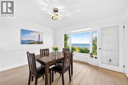 Dining area featuring a prominent bay window with water scenery - 15 Cheval Drive, Grimsby, ON - Indoor Photo Showing Dining Room