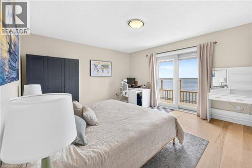 Sliding glass doors opening to a private balcony overlooking the water - 15 Cheval Drive, Grimsby, ON - Indoor Photo Showing Bedroom