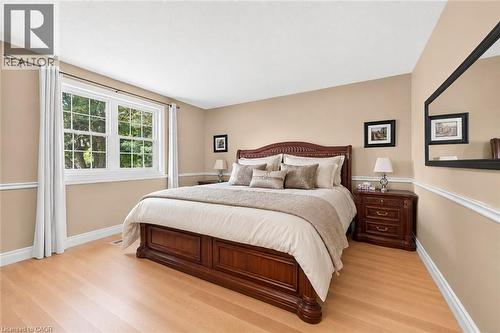 Bedroom with light wood-finish flooring, a large window, neutral wall paint, white trim, and crown molding - 15 Cheval Drive, Grimsby, ON - Indoor Photo Showing Bedroom