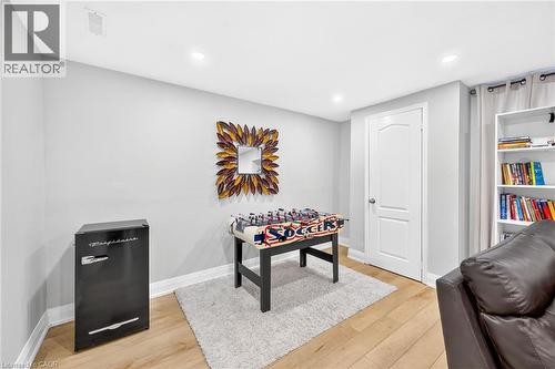 Finished room featuring light wood-finish flooring, recessed lighting, a built-in white bookshelf, and light gray wall paint - 15 Cheval Drive, Grimsby, ON - Indoor
