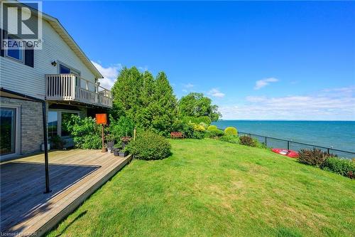 Expansive grassy lawn with water frontage and black metal fencing - 15 Cheval Drive, Grimsby, ON - Outdoor With Body Of Water With Balcony With Deck Patio Veranda