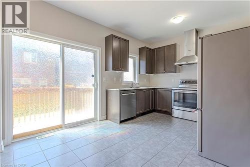 Kitchen featuring dark wood-finish cabinetry, stainless steel appliances, and light-toned countertops - 3896 Tufgar Crescent, Burlington, ON 