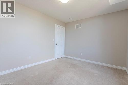 Neutral tone wall paint with white trim, light-colored carpet, and a white interior door - 3896 Tufgar Crescent, Burlington, ON 