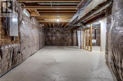 Unfinished basement featuring exposed wood joists, concrete flooring, and a utility sink - 3896 Tufgar Crescent, Burlington, ON 