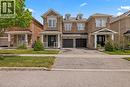 Brick exterior residence featuring a covered front porch with white railings, a black front door, a two-car garage, and dormer windows - 4670 Thomas Alton Boulevard, Burlington, ON 