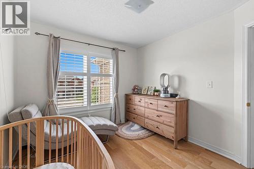 Bright room with light wood-finish flooring, white walls, a large window with white blinds and drapes, and a ceiling-mounted light fixture - 4670 Thomas Alton Boulevard, Burlington, ON 