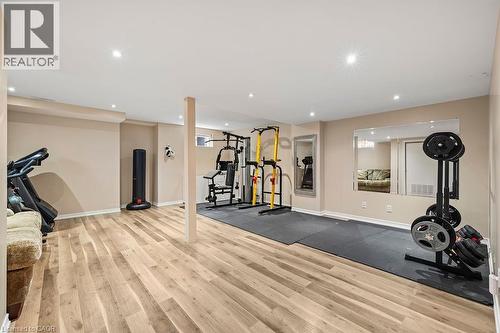 Spacious recreational room featuring wood-finish flooring, recessed lighting, and a neutral color palette - 4670 Thomas Alton Boulevard, Burlington, ON 