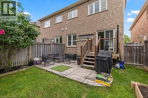 Expansive rear yard featuring a paved patio area, wood deck with stairs, privacy fencing, and a raised garden bed - 4670 Thomas Alton Boulevard, Burlington, ON 