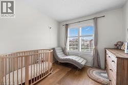 Bright room featuring wood-finish flooring, white walls, and a large window with white louvered blinds - 