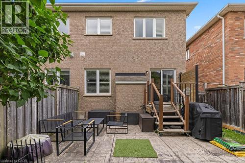 Rear exterior featuring a brick facade with multiple windows - 4670 Thomas Alton Boulevard, Burlington, ON 