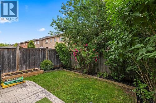 Private backyard featuring a stamped concrete patio, a raised garden bed, and a wooden privacy fence - 4670 Thomas Alton Boulevard, Burlington, ON 