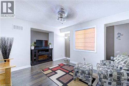 Living space featuring wood-finish flooring, a wall niche, and a window with a Roman shade - 1406 Marshall Crescent, Milton, ON 