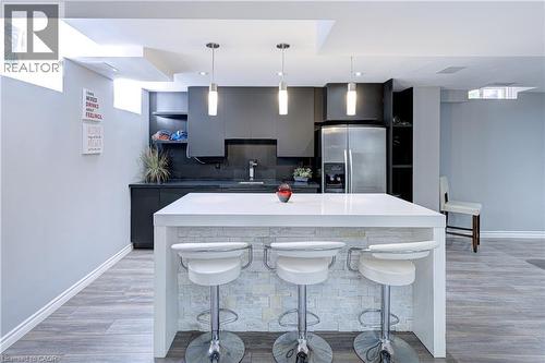 Contemporary kitchen island with a white countertop and stacked stone facade - 1406 Marshall Crescent, Milton, ON 
