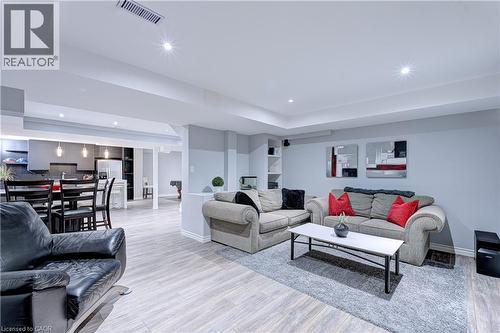 Spacious open-concept interior featuring light wood-finish flooring, recessed lighting, and light gray walls - 1406 Marshall Crescent, Milton, ON 