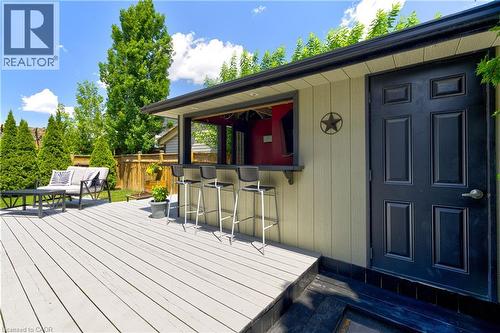 Expansive outdoor deck featuring composite decking, a built-in bar, and a detached structure with a paneled exterior - 1406 Marshall Crescent, Milton, ON 