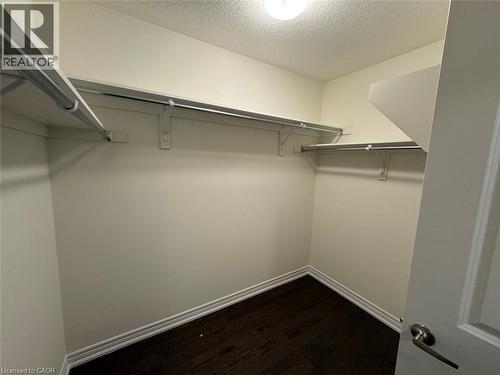 Well-lit closet featuring wood-finish flooring and extensive shelving with hanging rods - 10 Guernsey Drive Unit# Upper, Kitchener, ON 