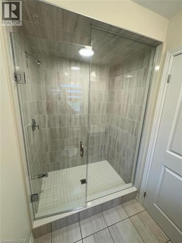 Enclosed shower with clear glass door, chrome hardware, light gray tile walls, mosaic tile floor, and recessed lighting - 10 Guernsey Drive Unit# Upper, Kitchener, ON 
