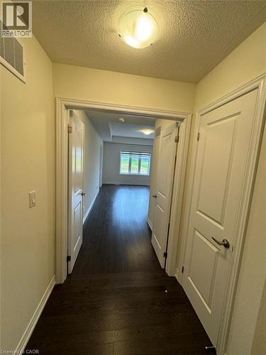 Hallway with dark wood-finish flooring, white trim, and a flush-mount ceiling light - 10 Guernsey Drive Unit# Upper, Kitchener, ON 