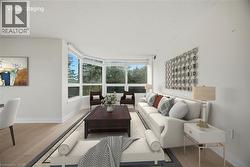 Expansive living area with large bay windows, providing abundant natural light and exterior views - 