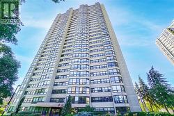 High-rise building with a light-colored facade, featuring numerous windows and recessed balconies - 