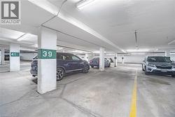 Underground parking garage featuring concrete flooring and structural columns - 