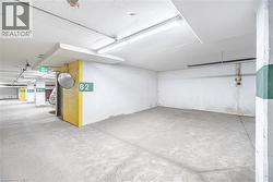 Designated parking space with concrete flooring, overhead lighting, and painted structural columns - 