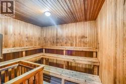 Wood-paneled sauna featuring tiered wooden benches and a slatted wood ceiling - 