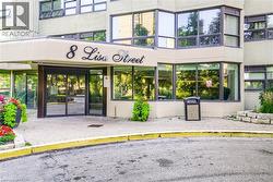 Building entrance featuring automatic glass doors, a stone facade, and large windows - 