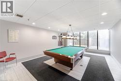 Recreation room featuring a classic billiards table with an overhead light fixture - 