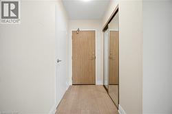 Entryway featuring wood-finish flooring, a white interior door, and a mirrored closet door - 