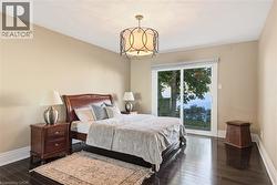 Bedroom featuring dark wood-finish flooring and light beige walls - 