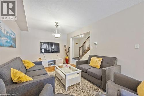 Bright living area featuring light-toned walls, wood-finish flooring, and a contemporary ceiling light fixture - 125 Terni Boulevard, Hamilton, ON 